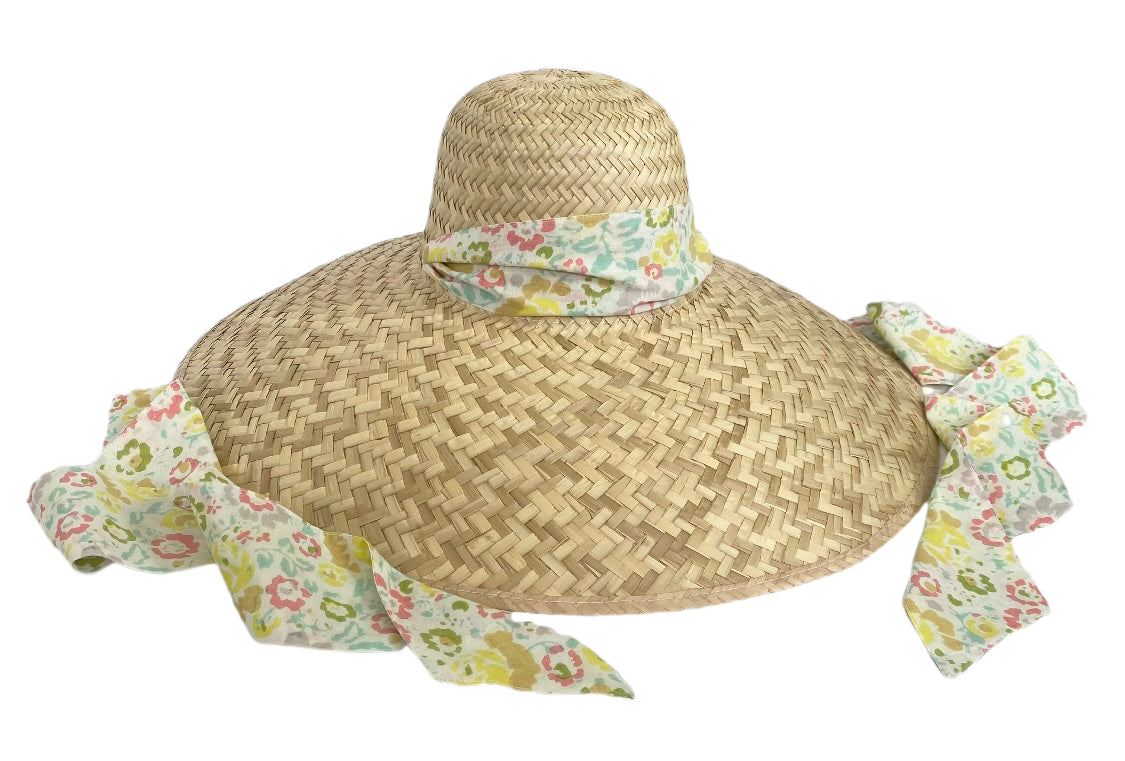 Front view of Geranium Sun Hat showcasing woven palm leaves and pastel floral ribbon with a white background