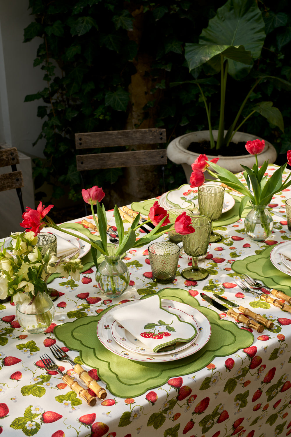 Top view of green strawberry placemat and napkin set with scalloped edges, double-layer trim, and strawberry embroidery