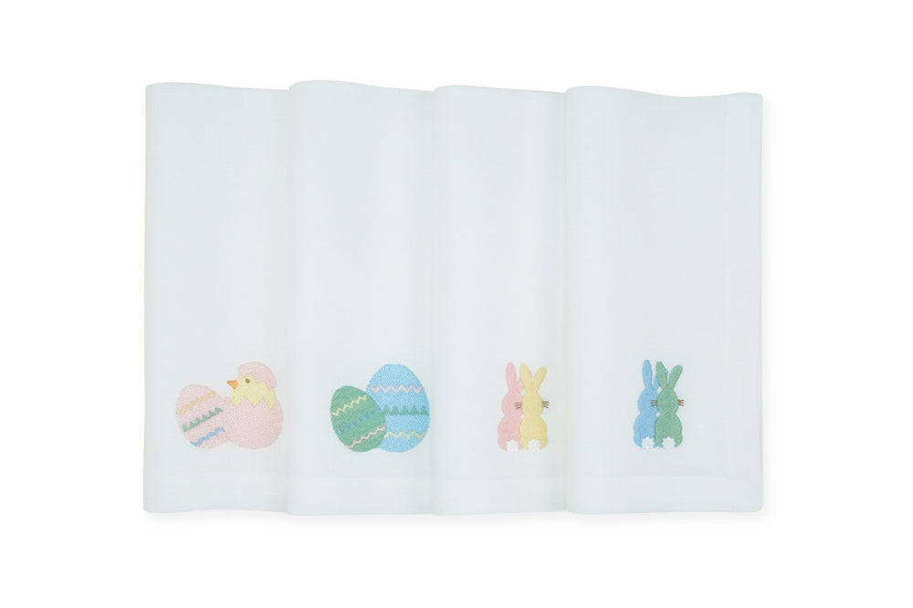 Front view of set of 4 white linen napkins showcasing embroidered pastel Easter motifs: chick, decorated eggs, and pink and blue bunnies