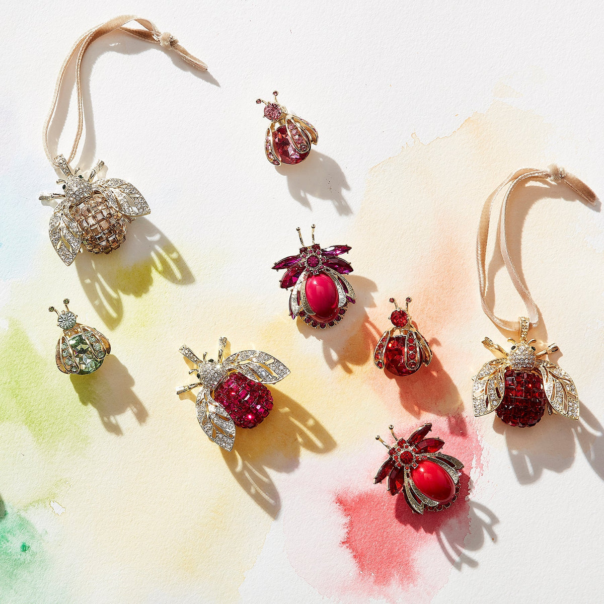 Overhead view of Gem Bug Clip Set in Rainbow showcasing jeweled bug clips in assorted colors on a watercolor background