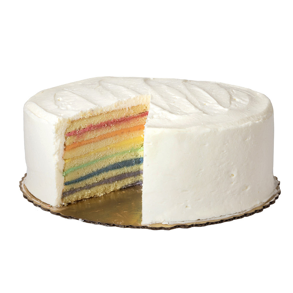 Side view of Over the Rainbow Cake, slice removed to reveal seven rainbow-colored layers and white buttercream frosting