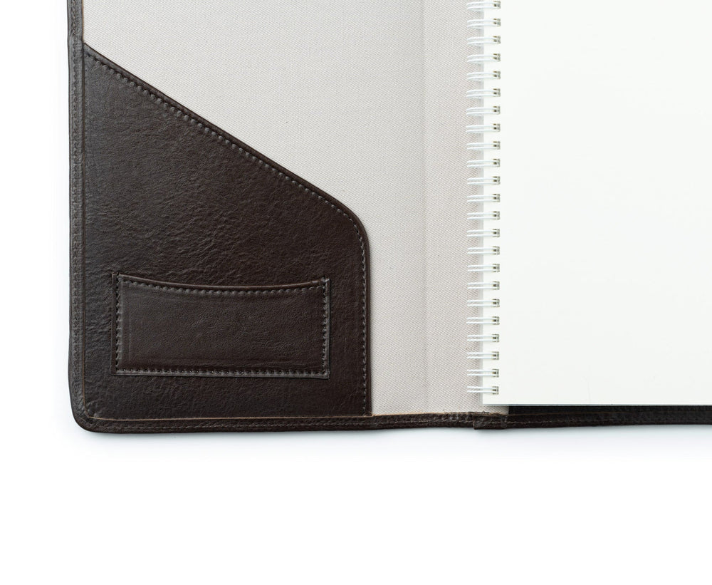 Interior of refillable journal in vintage walnut leather showing left leather pocket and spiral-bound refill