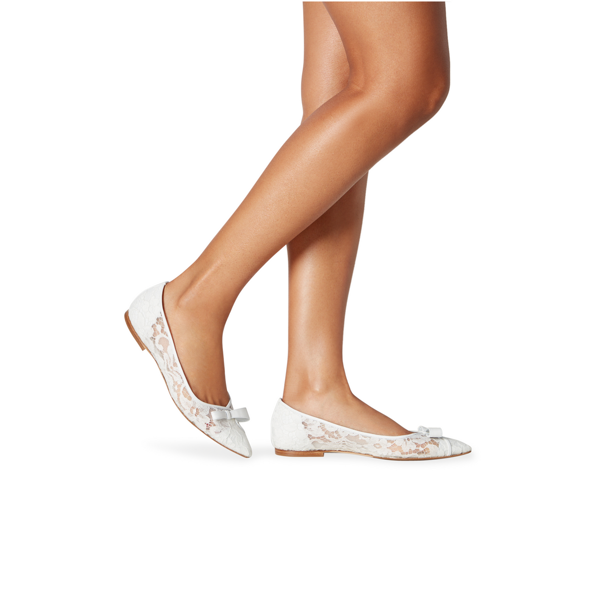 Side view of Natalie white lace ballerina slippers showcasing pointed toes and bows on a model against a white background