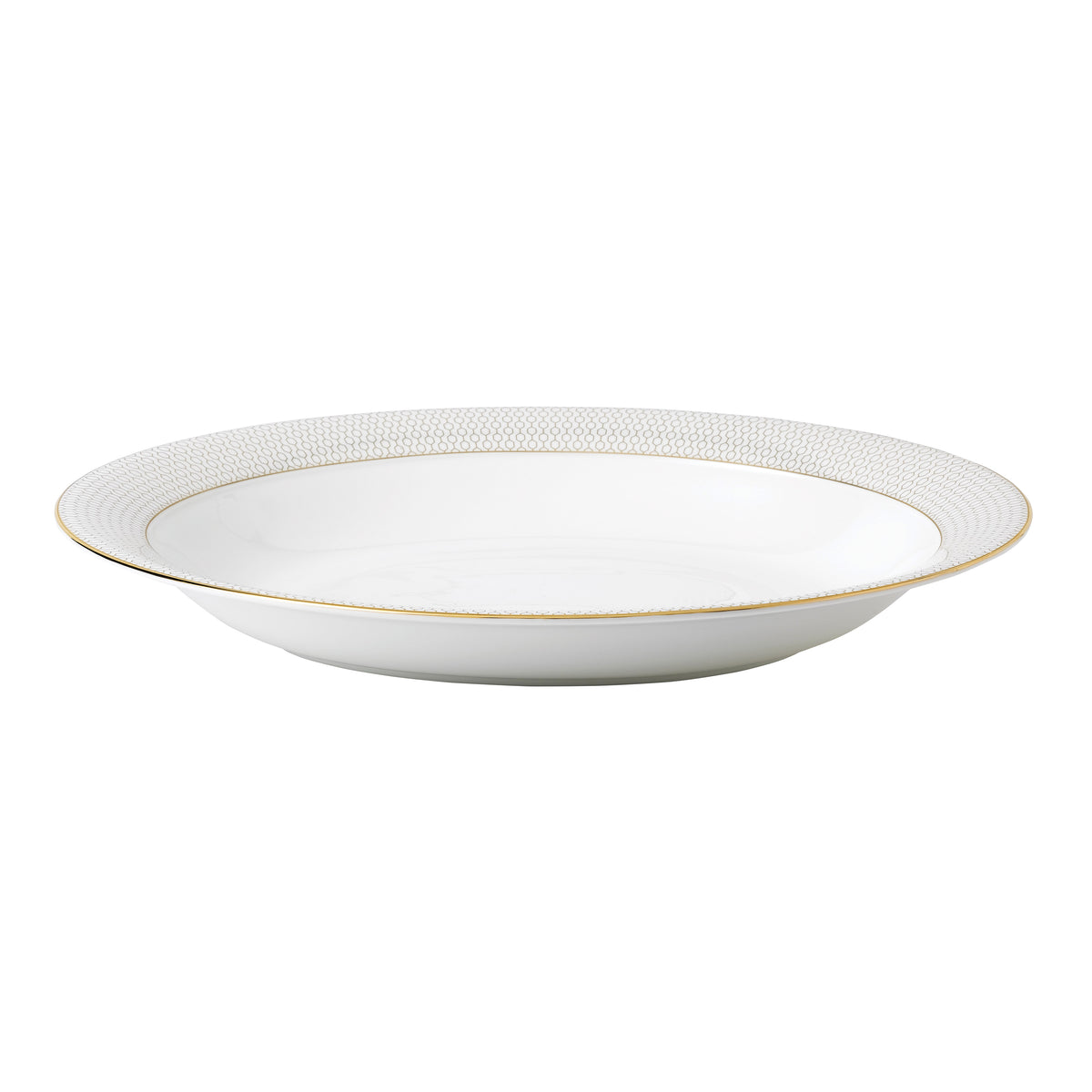 Front three-quarter view of the Gio Gold Oval Serving Bowl showcasing its embossed geometric pattern and gold rim on a white background
