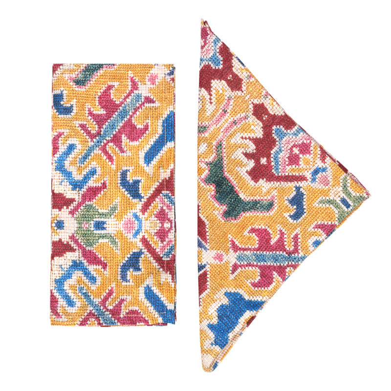 Front and folded views of Fiamma Napkins in Yellow, Set of 4 showcasing colorful patterned design on white background